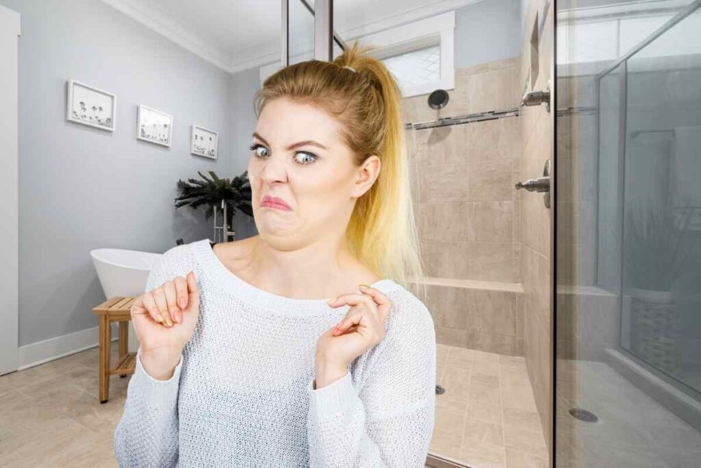 Bagno e donna con faccia disgustata
