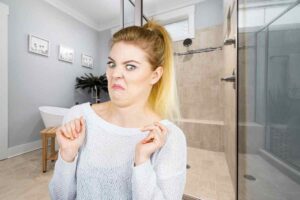 Bagno e donna con faccia disgustata