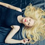 donna stesa con i capelli sparsi sul letto