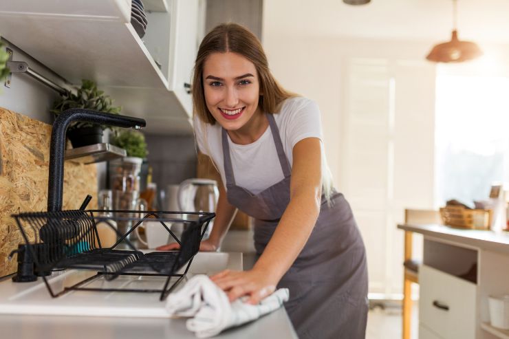 donna sorridente che pulisce la cucina