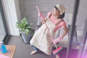 donna che balla mentre pulisce casa