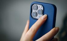 Mano di donna con smartphone in mano e cover blu
