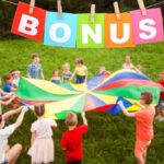 Bambini giocano con lenzuolo colorato e scritta bonus in alto