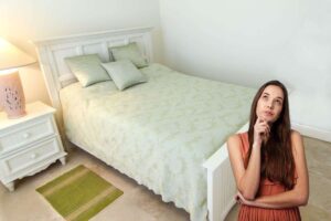 camera da letto piccola e una persona pensierosa