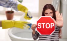 donna che pulisce wc e un'altra con cartello stop in mano