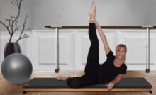 donna distesa su un tappetino da yoga con una gamba distesa in alto