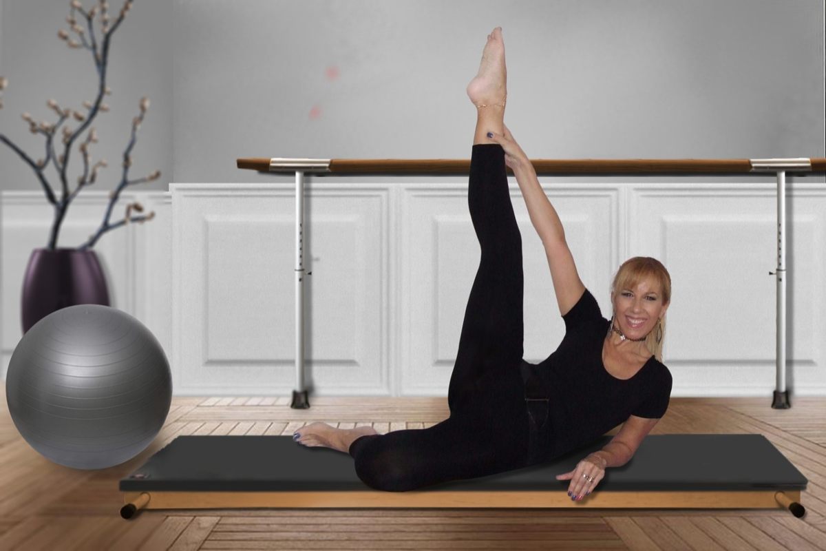 donna distesa su un tappetino da yoga con una gamba distesa in alto