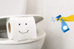 gabinetto con rotolo di carta igienica con disegnato un sorriso e una mano con guanto in lattice e spruzzino