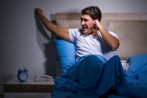 uomo disturbato dai rumori e non riesce a dormire