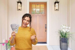 donna che esulta con soldi e porta di ingresso