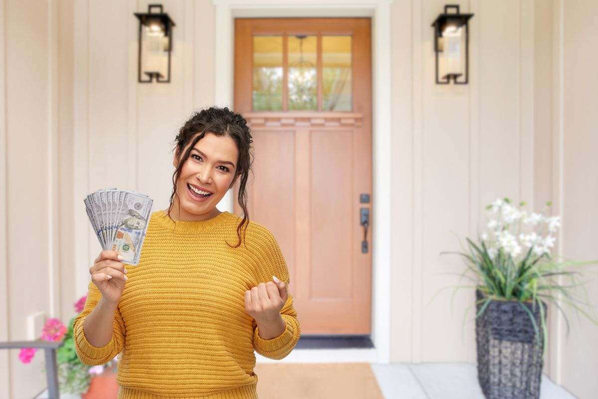 donna che esulta con soldi e porta di ingresso