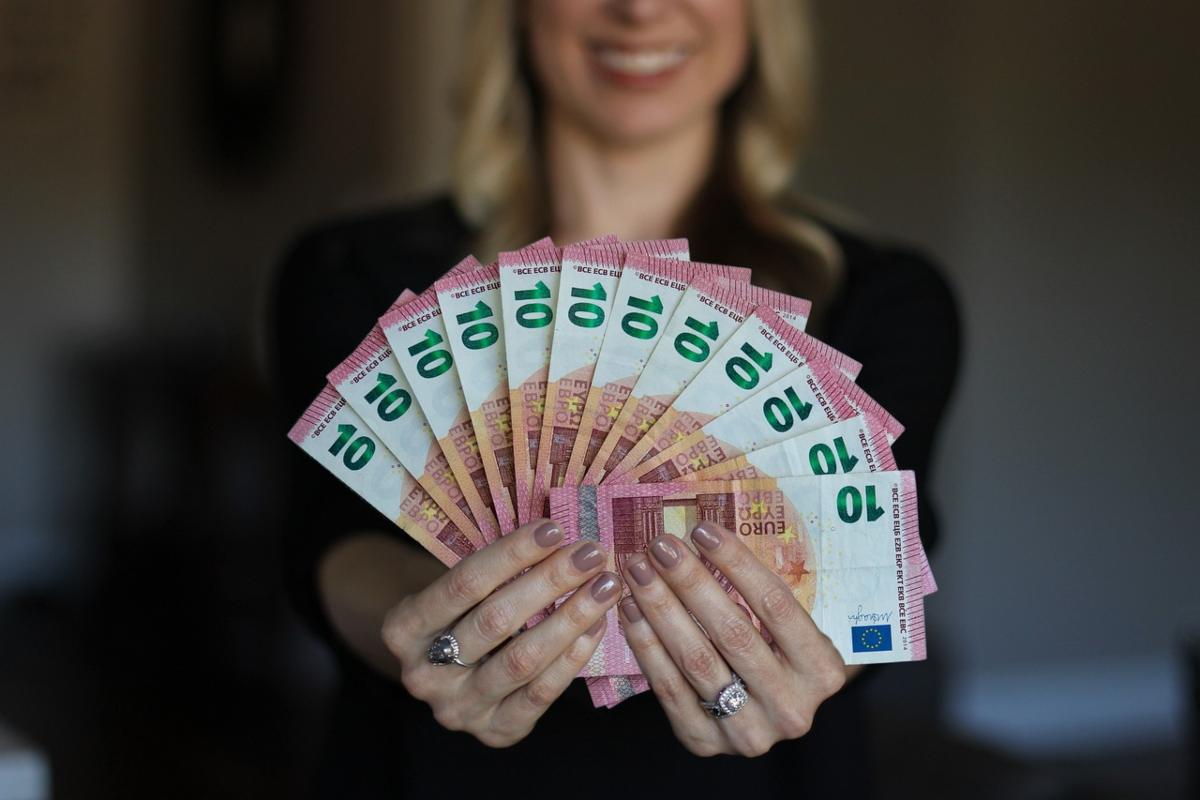 donna con in mano tante banconote da 100 euro