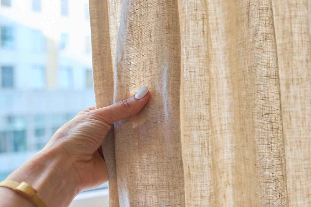 mano che tocca una tenda