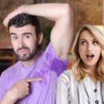 donna con un'idea e uomo che mostra la macchia di sudore sotto la maglia