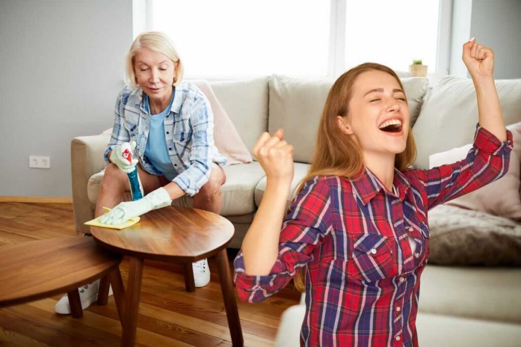 donna che rimuove polvere e un'altra che esulta