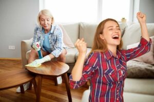 donna che rimuove polvere e un'altra che esulta